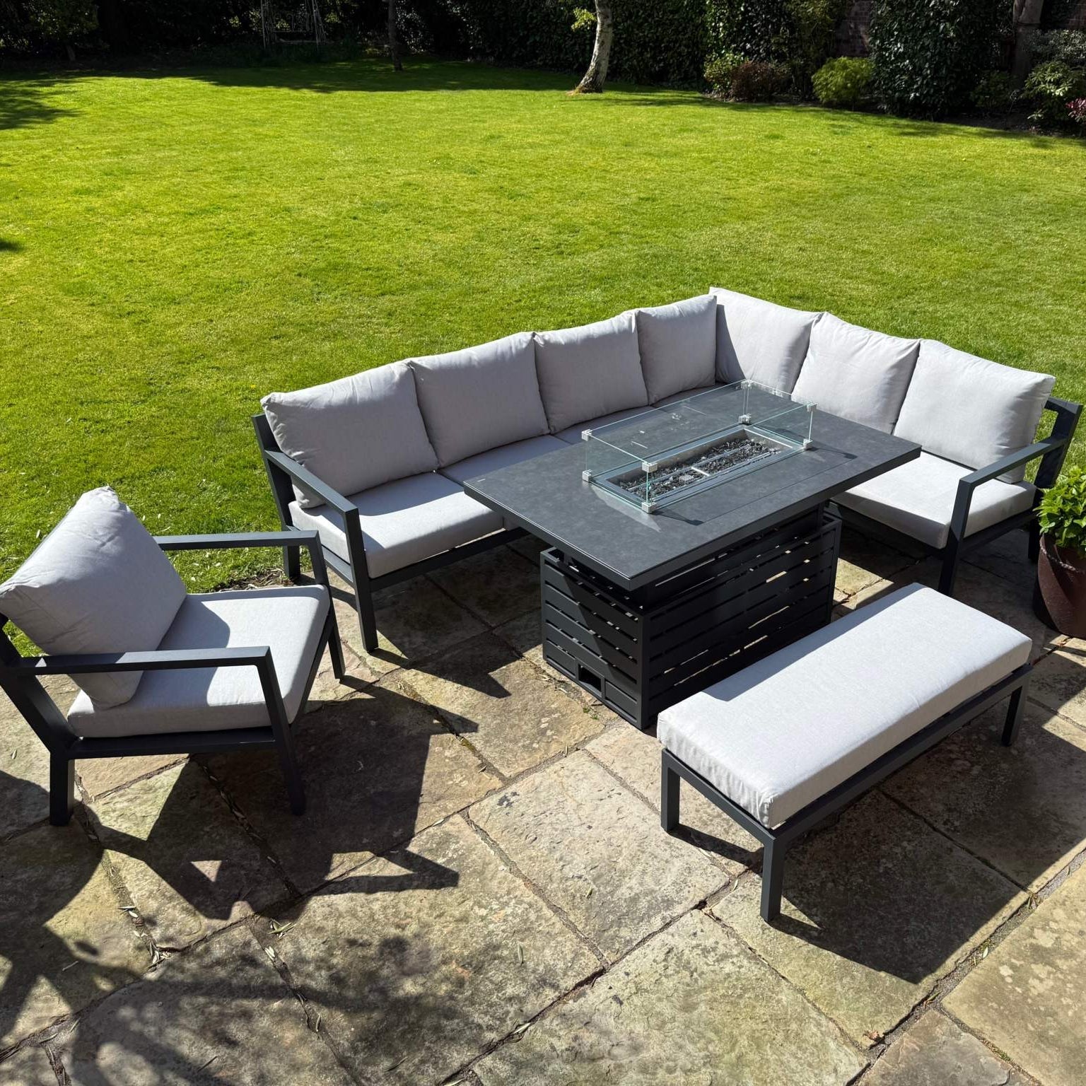 Torino Aluminium Fire Pit outdoor corner sofa set with rising table and deep seat cushions in modern garden setting