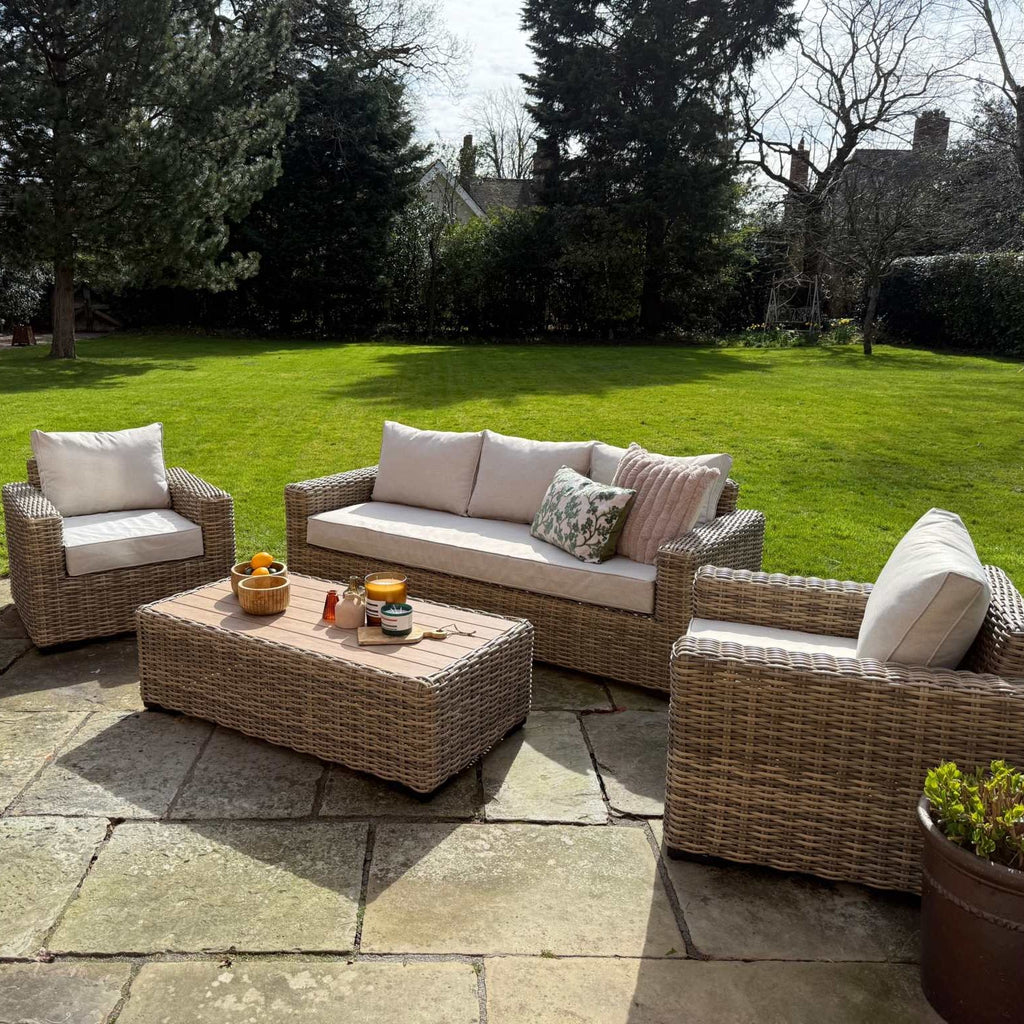 Portofino Grand Weave garden furniture sofa set with natural rattan weave and neutral cushions on patio