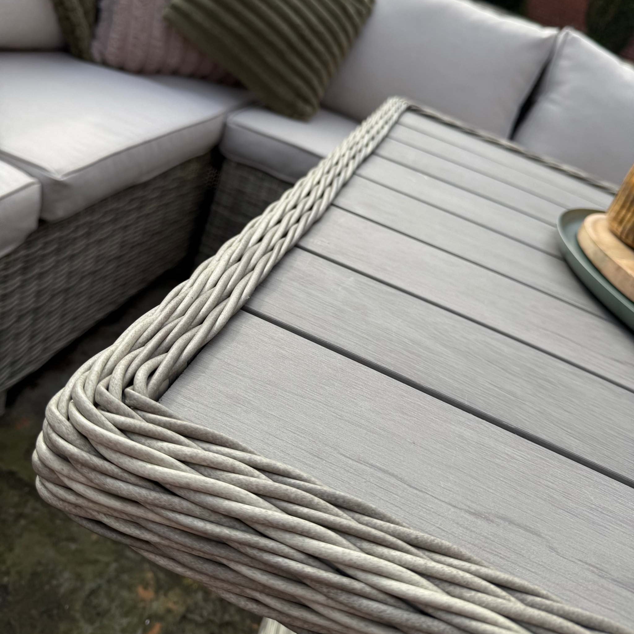 Sienna Corner Rattan Garden Set with rising table, armchair, and footstools in natural rattan with neutral cushions for outdoor patio and garden seating