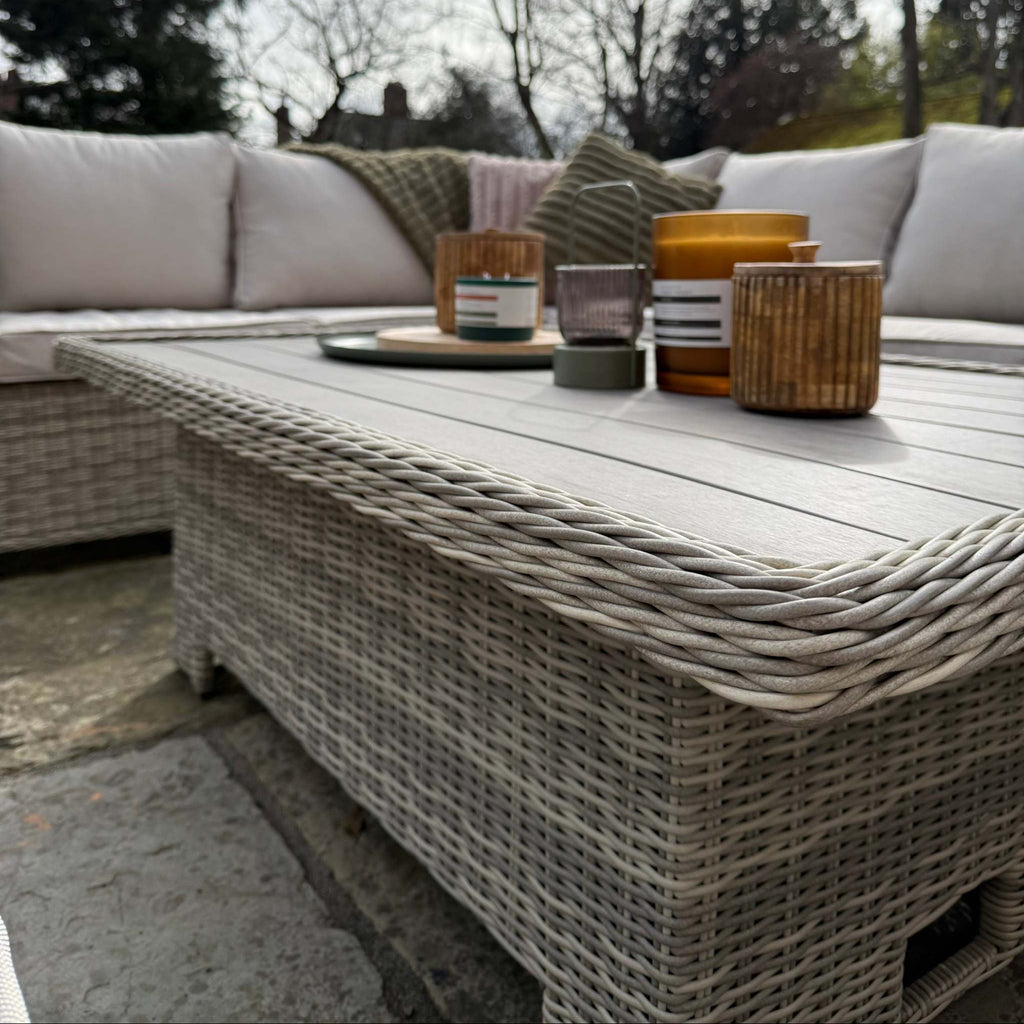 Sienna Corner Rattan Garden Set with rising table, armchair, and footstools in natural rattan with neutral cushions for outdoor patio lounging and dining