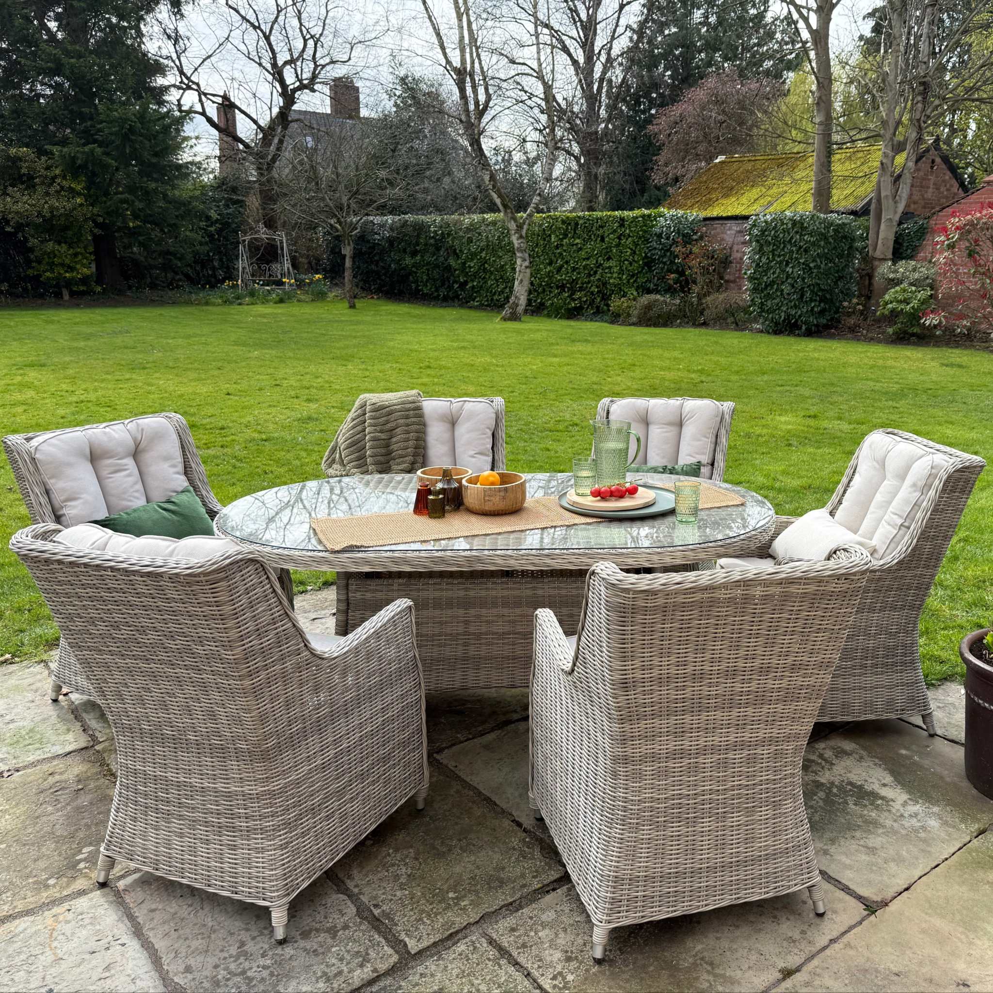 Sienna 6 Seater Oval Outdoor Dining Set with High Back Chairs and cream cushions on natural rattan weave