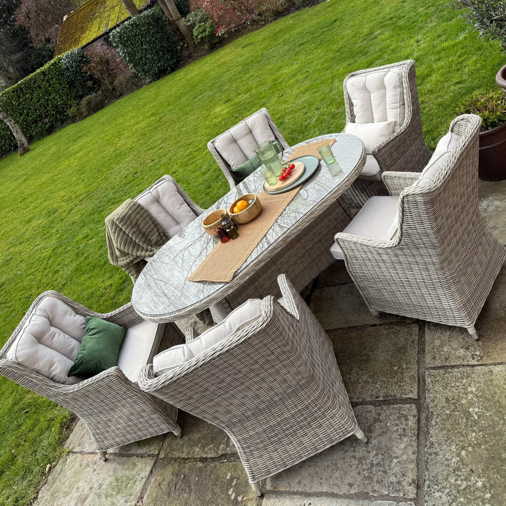 Outdoor patio set with table and chairs on a grassy area.