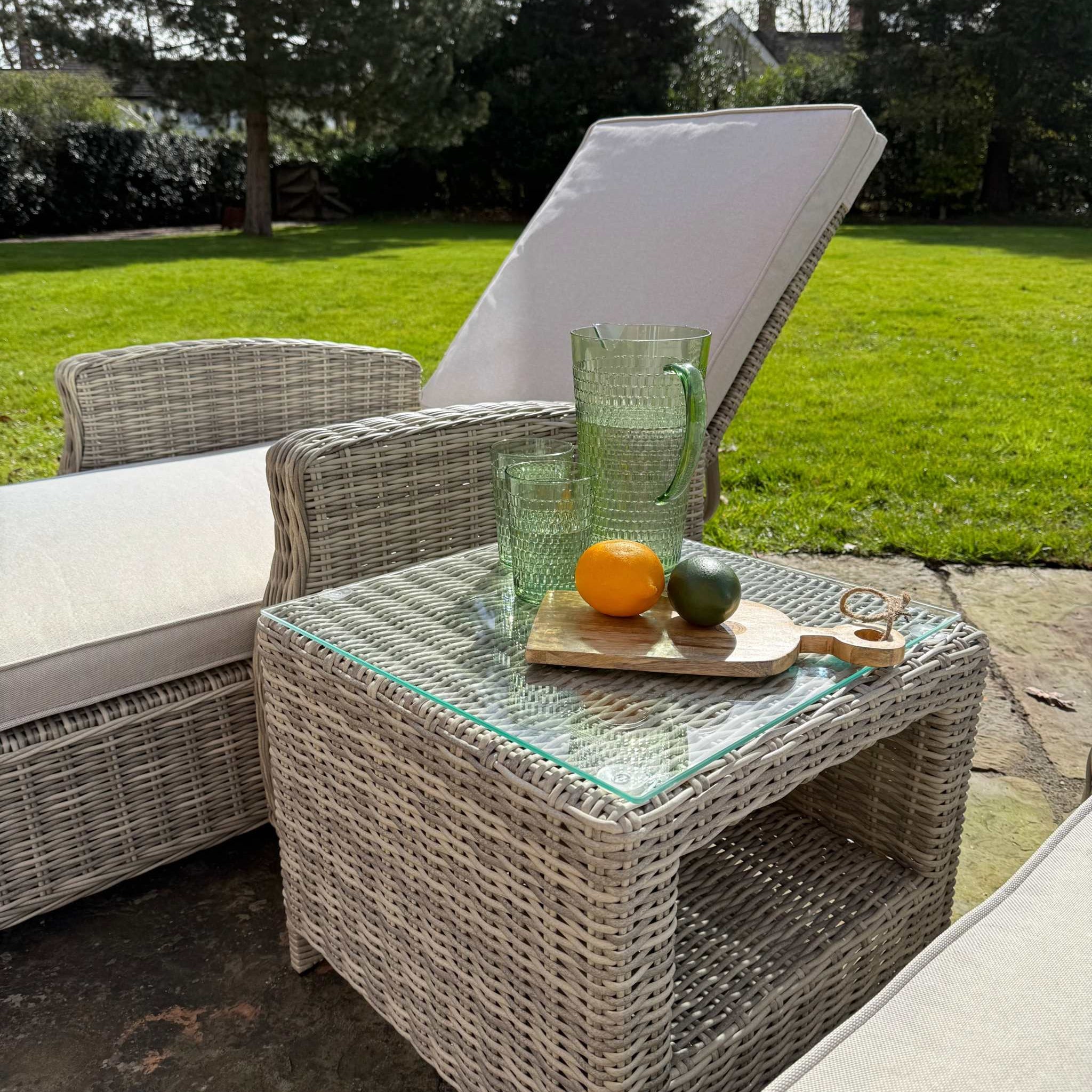 Sienna Twin Sun Lounger Set with cream cushions and glass top table on patio