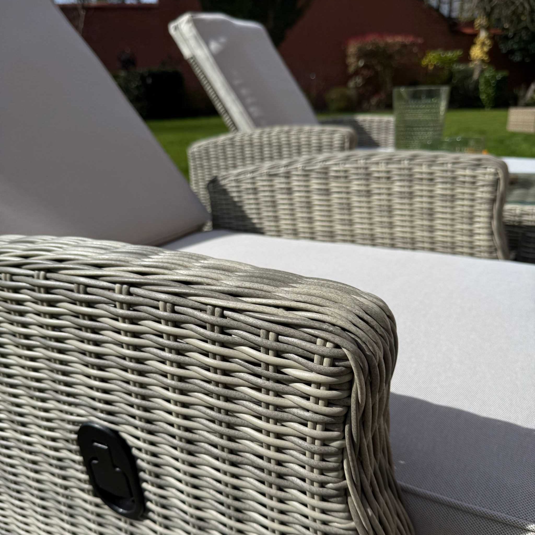 Sienna Twin Sun Lounger Set with natural rattan weave, cream cushions, and glass top side table outdoors
